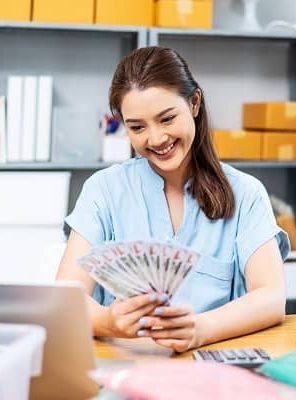 young-asian-woman-holding-us-dollars-money-lot-of-2023-11-27-05-08-37-utc (1)
